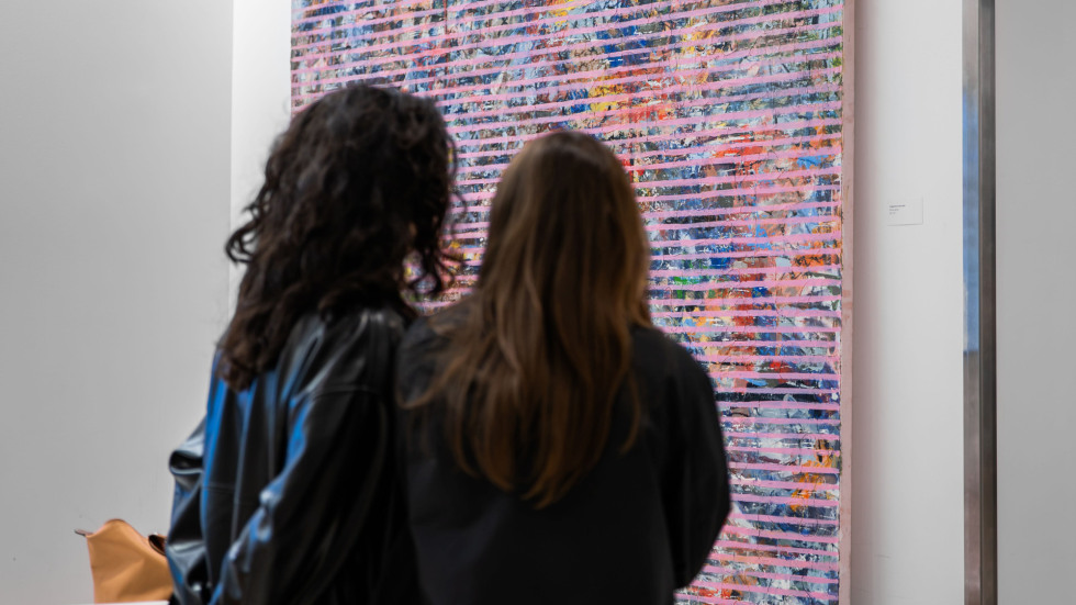 Two people looking at painting